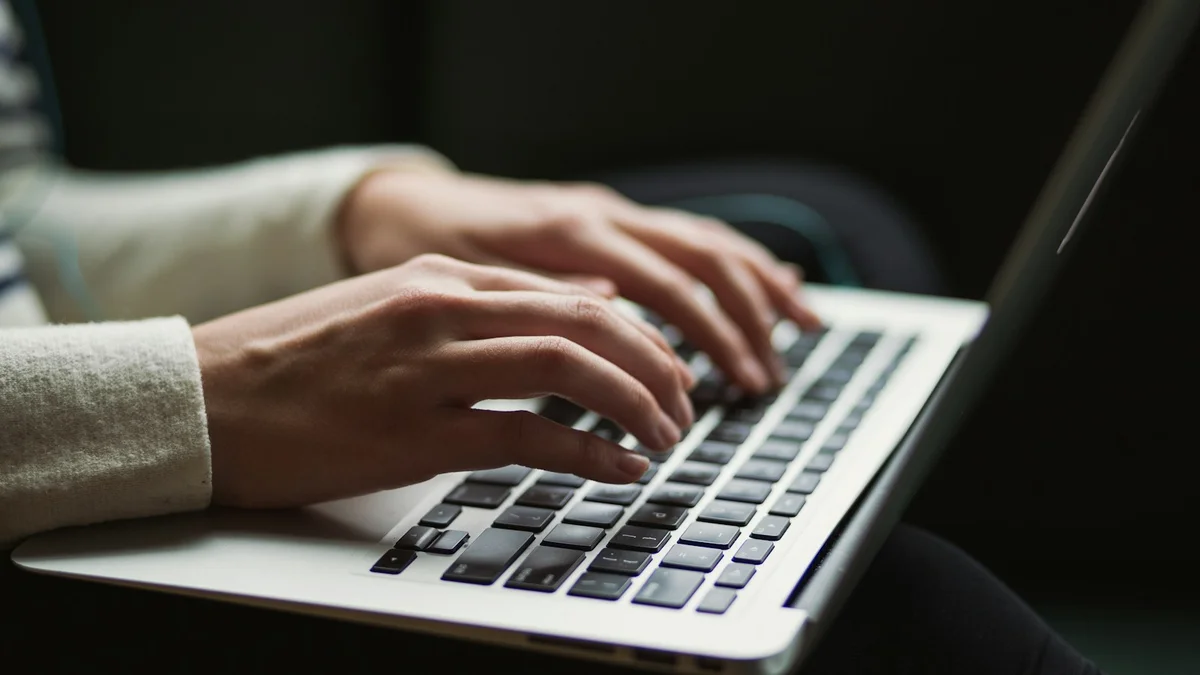 Tangan pengguna mengetik di laptop untuk pemeliharaan sistem komputer