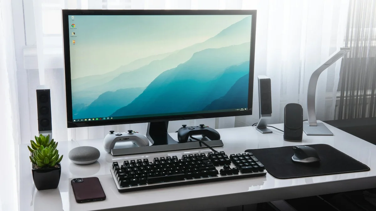 Komputer desktop dengan monitor dan keyboard di meja kerja